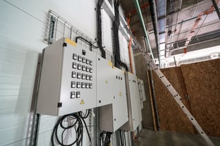 Electrical control panels with wiring and switches, located in a modern industrial facility